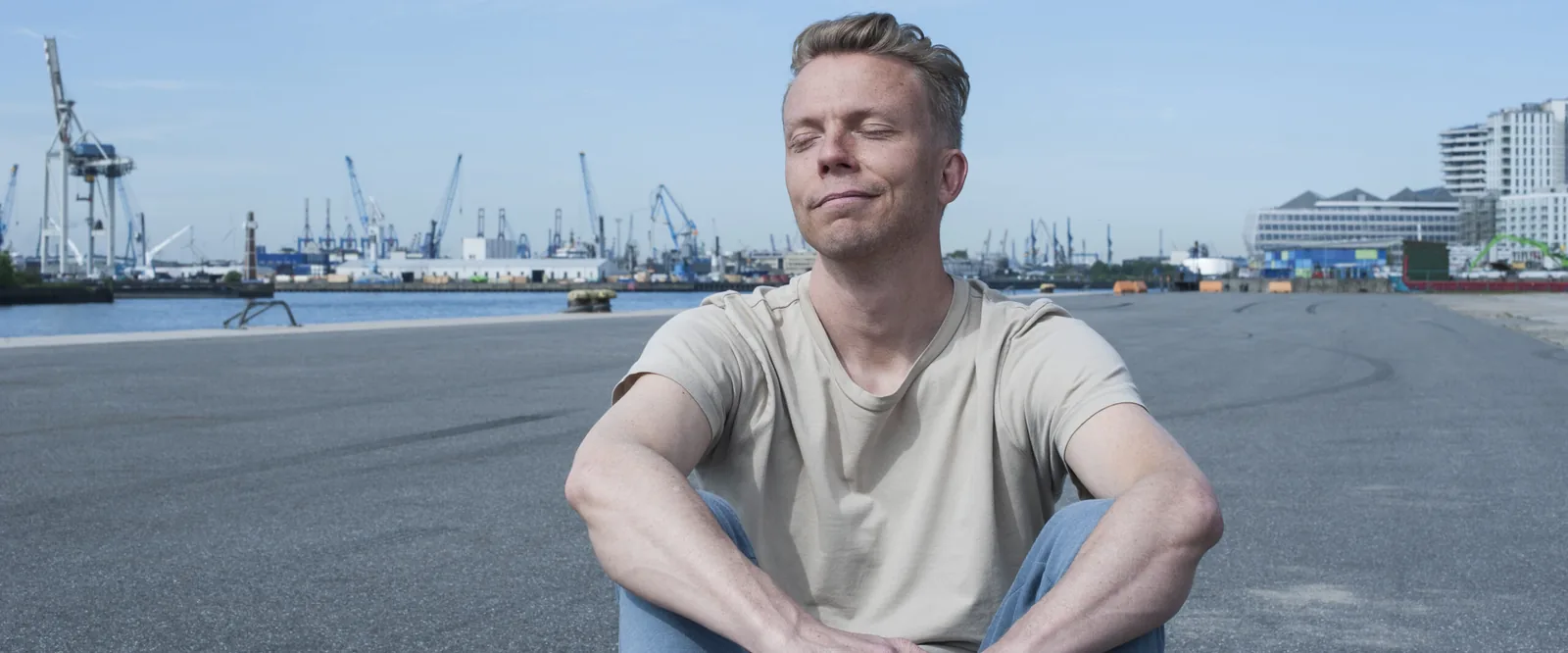 Jan Wolk, Inhaber von Somatic Web, in stiller Sammlung vor der Hamburger Hafenkulisse