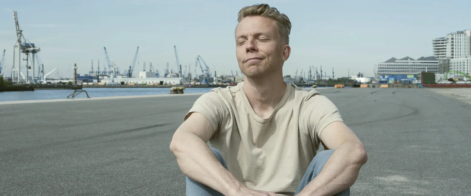 Jan Wolk, Inhaber von Somatic Web, sitzt mit geschlossenen Augen am Hamburger Hafen